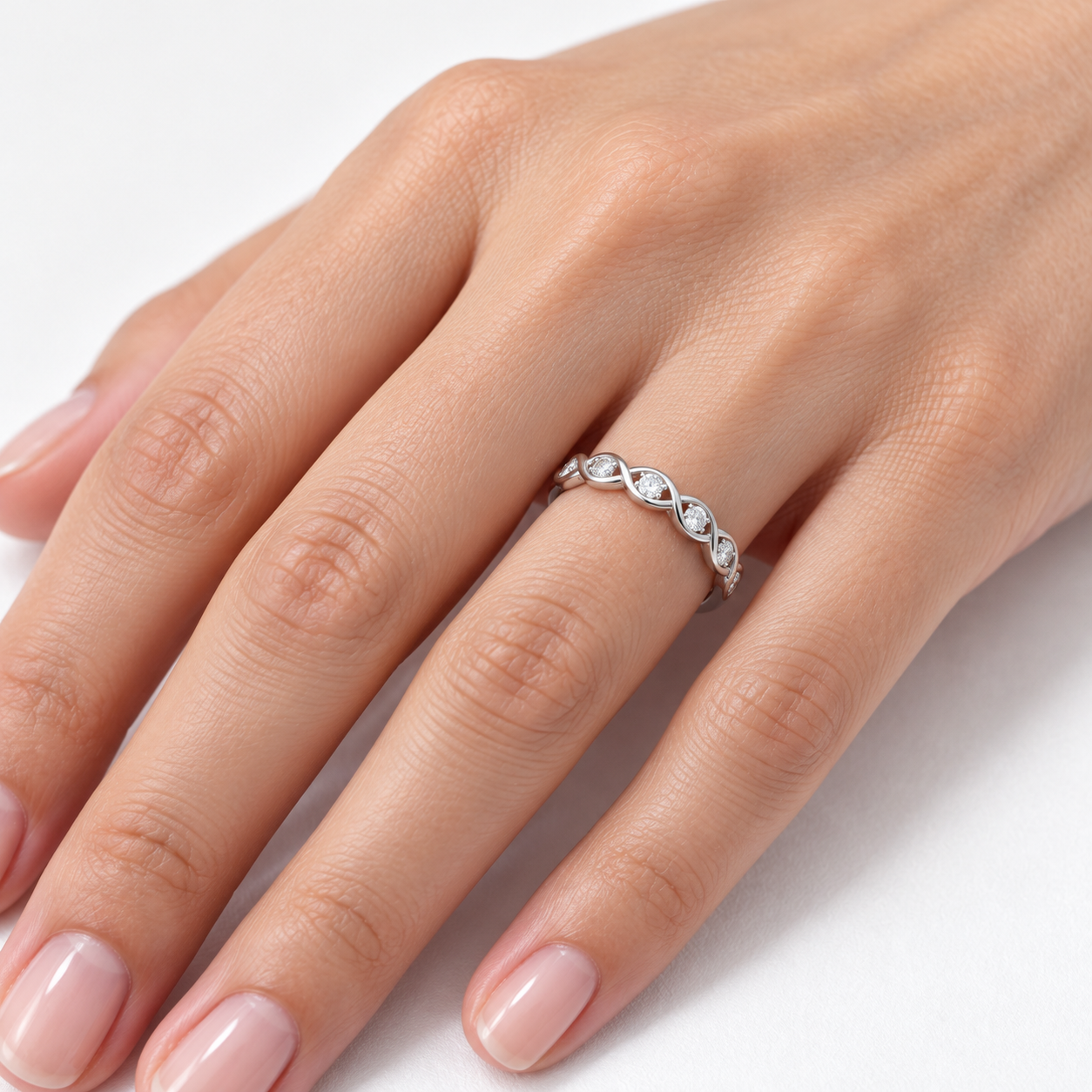 intertwining white gold ring on a woman’s hand 2 intertwining white gold ring on a woman’s hand 2